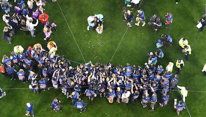 Los jugadores del Real Madrid rodeados de fotógrafos junto a la Copa de Europa.