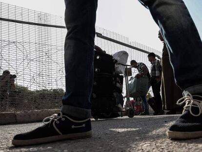 Un grupo de palestinos espera para recibir permisos y cruzar a Egipto. 