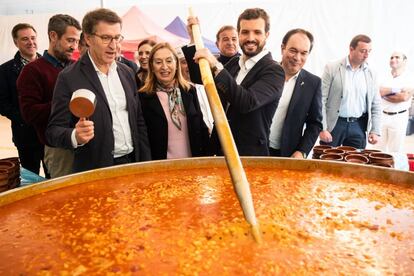 El presidente del Partido Popular, Pablo Casado (segundo por la derecha), junto al presidente de la Xunta, Alberto Núñez Feijóo (izquierda), el alcalde de la Lalín, José Crespo, (derecha) y la candidata Ana Pastor, junto a una gran olla con cocido en la localidad pontevedresa de Lalín, este sábado.