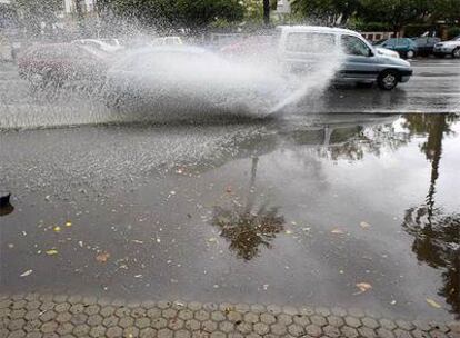 Un coche pasa por un tramo inundado en Sevilla.