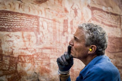 Carlos Castaño-Uribe observa las pinturas de Chiribiquete.