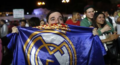 Un aficionado del Real Madrid cubierto con la bandera de su equipo.