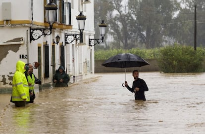 Varias personas, entre las casas inundadas en la barriada Doña Ana de la localidad de Cártama (Málaga) por las fuertes lluvias.