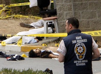 Un policía turco observa los cuerpos de las víctimas del tiroteo.