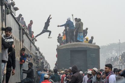 Un devoto musulmán salta de un tren a otro para participar en las oraciones finales, durante la reunión anual musulmana Biswa Ijtema en Tongi, en Daca (Bangladés), el 12 de enero.