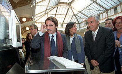 José María Aznar y el secretario general del PP, Javier Arenas, con jóvenes de su partido en la Casa del Reloj, en Madrid.