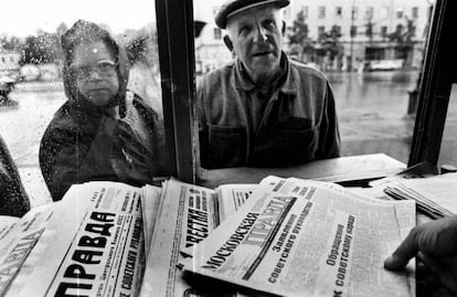 Dois cidadãos russos se aproximam de uma banca para comprar um jornal com a manchete “Anúncio ao povo soviético” por parte dos líderes do golpe, em 20 de agosto de 1991, em Moscou.