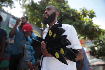 Nertil Marcelin, leader of a community group, holds a bunch of machetes to distribute to residents in an initiative to fight gangs seeking to take control of their neighborhood in the Delmas district of Port-au-Prince, Haiti, Sunday, May 28, 2023.