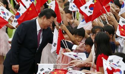El presidente chino, Xi Jinping, saluda a unos ni&ntilde;os durante la ceremonia de bienvenida en la Casa Azul, sede del Gobierno, en Se&uacute;l. 