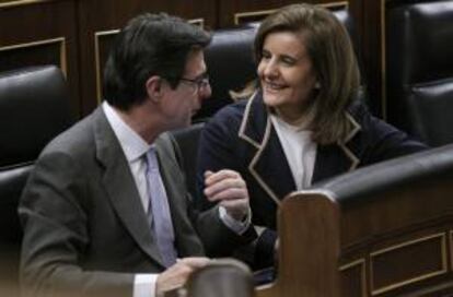 El ministro de Industria José Manuel Soria, conversa con la ministra de Empleo, Fátima Báñez, durante el pleno celebrado ayer en el Congreso de los Diputados.