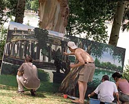 Cuatro participantes en el Certamen de Pintura Rápida del Retiro trabajan en un mismo cuadro.