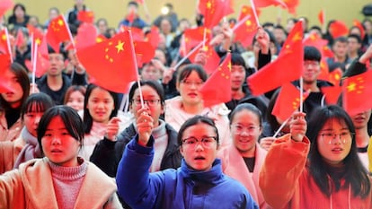 Varios estudiantes de una universidad de la provincia de Anhui ondean banderas de China.