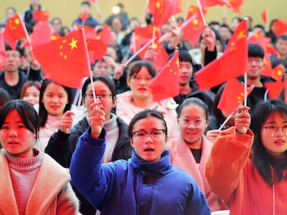 Varios estudiantes de una universidad de la provincia de Anhui ondean banderas de China.