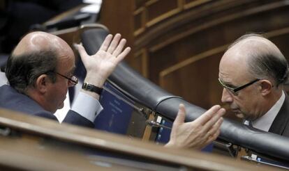 Luis de Guindos y Cristóbal Montoro, conversan durante el Pleno del Congreso.