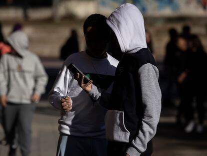 Alumnos utilizando sus teléfonos móviles durante un recreo.