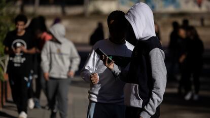 Alumnos utilizando sus teléfonos móviles durante un recreo.