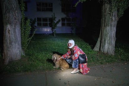Una mujer herida acaricia a su perro tras el ataque ruso sobre un barrio residencial en Kiev, este jueves. 