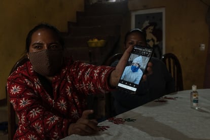 Jazmín Mejía, junto a su hermana mayor, Giselle Mejía, muestra en el celular el traje que usó para reconocer a su tía en la morgue, tras la muerte de esta por covid-19.