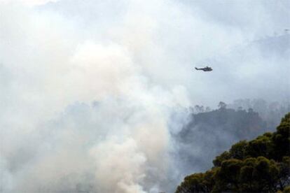Un helicóptero sobrevuela la zona afectada por el incendio en el parque natural de Cazorla.