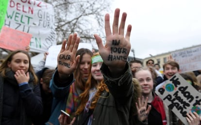 "Nuestro futuro en tus manos" es el eslogan que tienen dos jóvenes pintado en sus manos durante la manifestación en Berlín (Alemania).