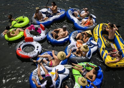 Un grupo de personas usa flotadores hinchables en un área recreativa sobre el río de los Americanos, cerca de Rancho Cordova (California, Estados Unidos).