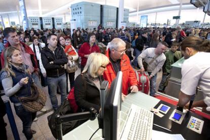 Un grupo de pasajeros hacen cola, ayer, para facturar sus maletas en la T-1 del aeropuerto de El Prat.