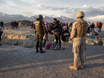 Agentes de la policía fronteriza chilena controlan a los migrantes que cruzaron ilegalmente a Chile desde la frontera con Bolivia