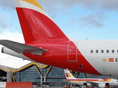 Un avi&oacute;n de Iberia con la nueva imagen en el aeropuerto de Barajas, junto a otros aparatos de la flota por actualizar.  / Pablo Monge