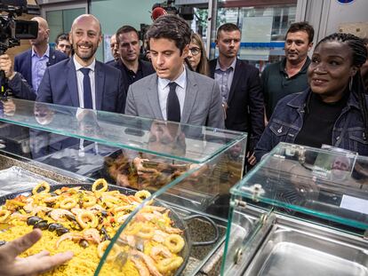 El primer ministro de Francia, Gabriel Attal (en el medio, con traje gris), durante una visita a un mercado en París, este martes.