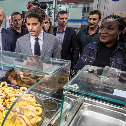 El primer ministro de Francia, Gabriel Attal (en el medio, con traje gris), durante una visita a un mercado en París, este martes.
