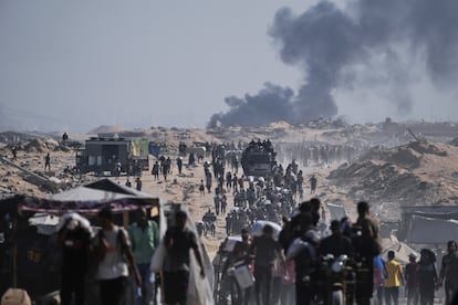 Decenas de palestinos cargan sacos de harina repartidos por un convoy de ayuda humanitaria en las afueras de Beit Lahiya, en el norte de Gaza, este sábado.
