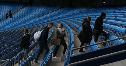 Cinco aficionados del Manchester City, en el estadio Etihad, visitan el campo de su equipo.