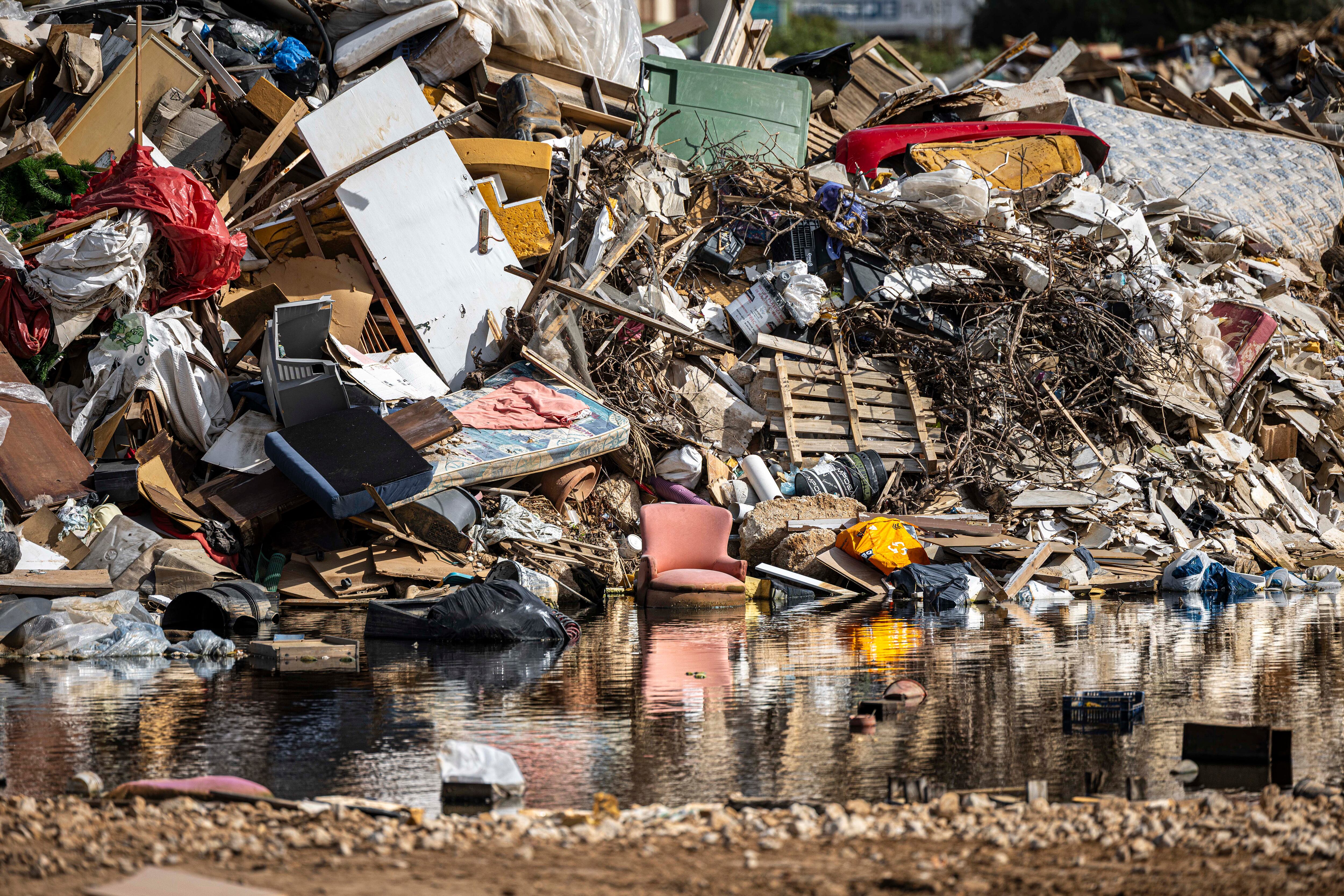 Restos de enseres y escombros que arrastró la dana cerca de un colegio a las afueras de Paiporta.