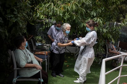 Una cuidadora atiende a varios ancianos de la residencia Gravi en Polinyà (Barcelona).