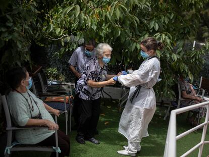 Una cuidadora atiende a varios ancianos de la residencia Gravi en Polinyà (Barcelona).