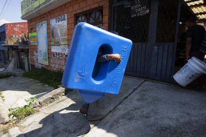 Un trabajador carga un sistema de captación de agua de lluvia de la empresa Isla Urbana.