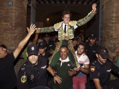 El torero Román sale, ayer domingo, por la puerta grande tras la última corrida de la Feria de Julio de Valencia.