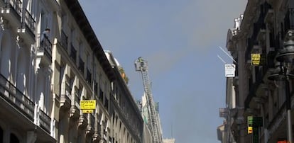 Los bomberos despliegan una escalera en el lugar del incendio.