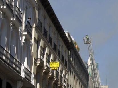 Los bomberos despliegan una escalera en el lugar del incendio.