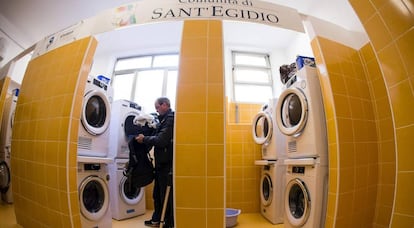 Un hombre mete ropa en una secadora en la lavander&iacute;a inaugurada el lunes en Roma.