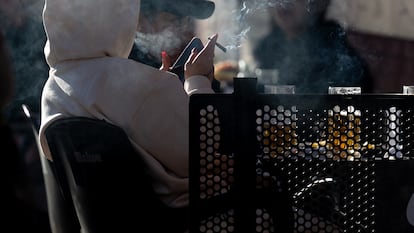 Una persona fuma en una terraza, en Madrid.