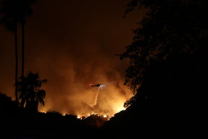 Un helicptero realiza un lanzamiento nocturno de agua sobre el incendio de 'Palisades', en la zona de Mandeville Canyon, en la noche del 10 de enero.