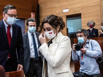 Isabel Díaz Ayuso, presidenta de la Comunidad de Madrid, junto a su escaño, acompañada de Alfonso Serrano, portavoz parlamentario del PP, y de Javier Fernández-Lasquetty, consejero de Hacienda.