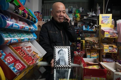 El comerciante Zhen Yu Jiang, en su tienda de alimentación de Parla, muestra el retrato de su esposa asesinada, Jia Ye.