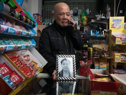 El comerciante Zhen Yu Jiang, en su tienda de alimentación de Parla, muestra el retrato de su esposa asesinada, Jia Ye.