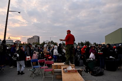 Sgt. Avery Parle updates the crowd waiting outside a local school, to get registered for an evacuation flight, as wildfires threatened the Northwest Territories town of Yellowknife, Canada, August 17, 2023.