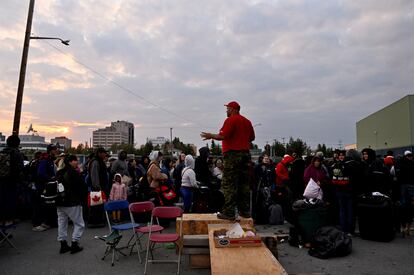 Sgt. Avery Parle updates the crowd waiting outside a local school, to get registered for an evacuation flight, as wildfires threatened the Northwest Territories town of Yellowknife, Canada, August 17, 2023.