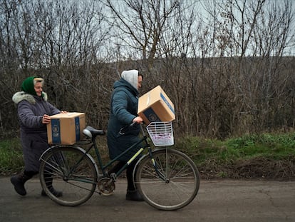 Two women returning home in Hnilitsia after collecting food rations on November 11.