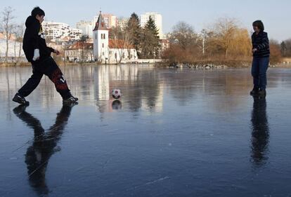 Dos niños juegan en un lago helado de Praga.