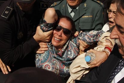 Spanish singer Isabel Pantoja is carried by the Spanish Civil Guard and police officers to a car after she collapsed while leaving court on Tuesday.